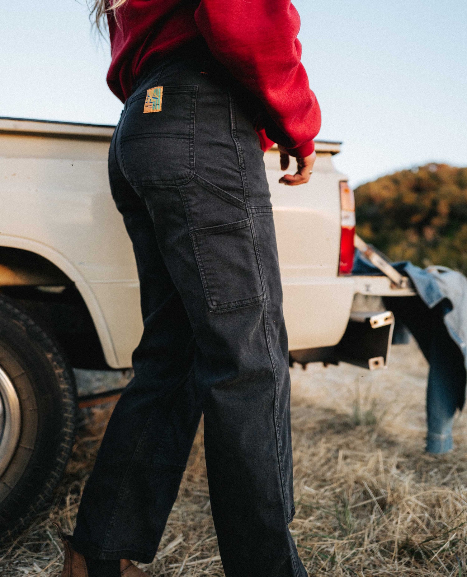Side image of superlite utility pants worn next to a pickup truck