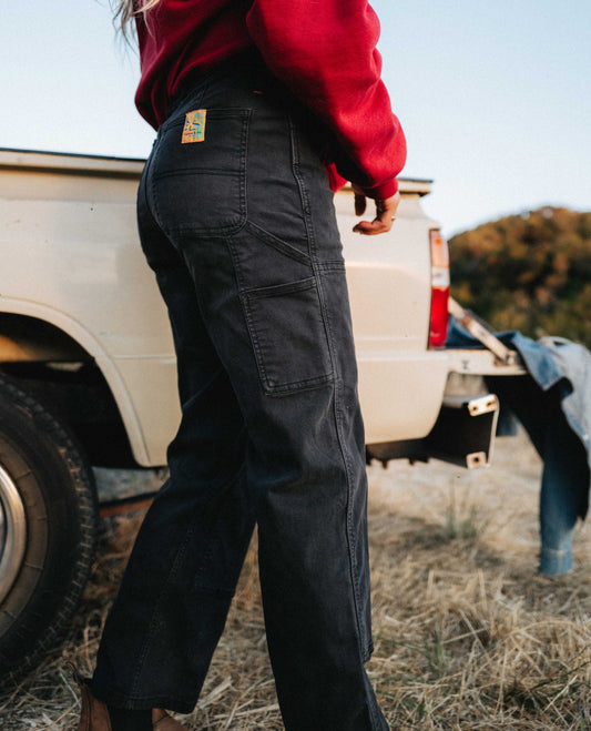 Side image of superlite utility pants worn next to a pickup truck