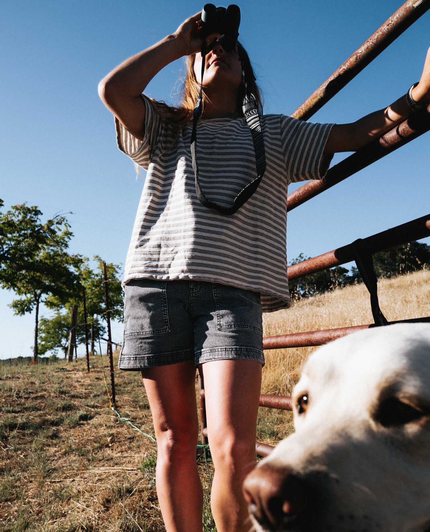 Girl in gray easy jorts looking through binoculars