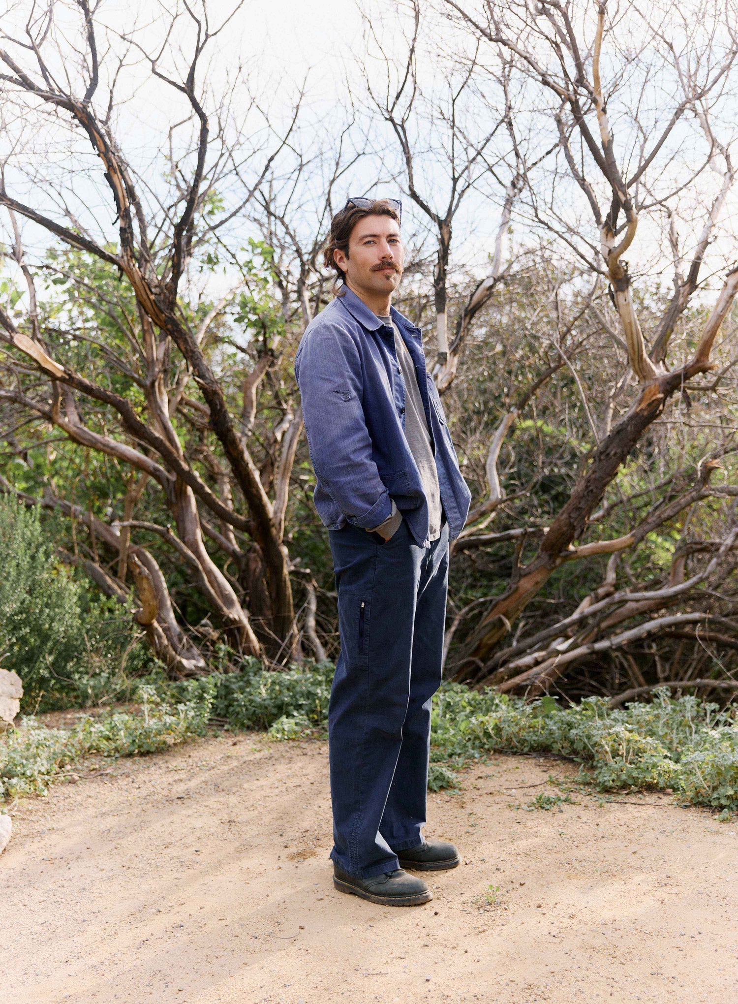 Man standing on a dirt path in a forested area