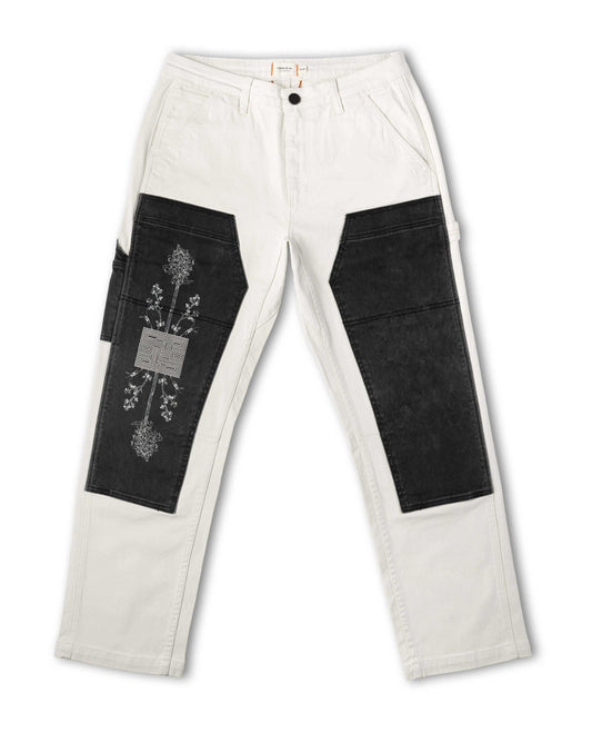 White pants with black patchwork design on a white background
