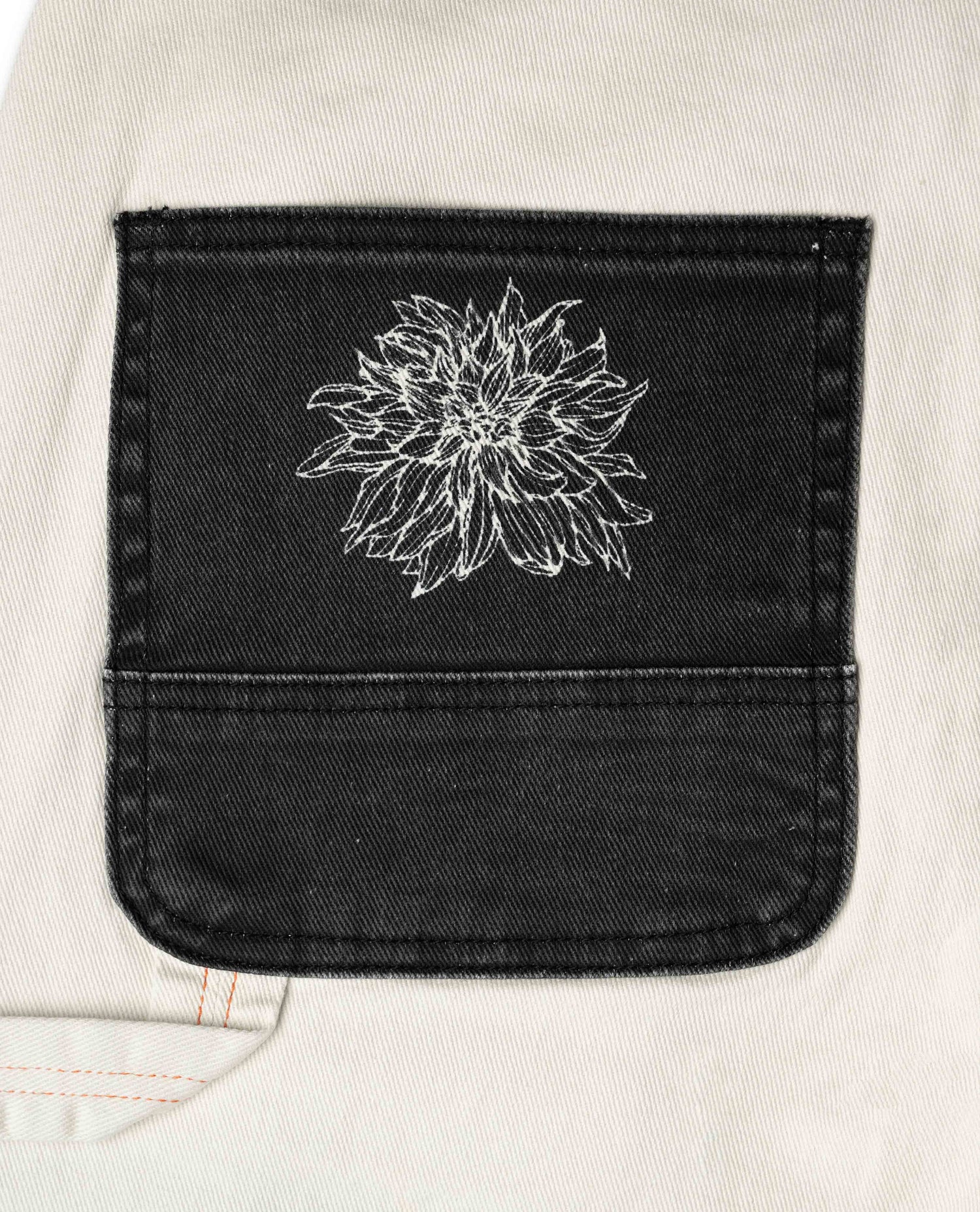 Black pocket on a light-colored garment with a white floral design.