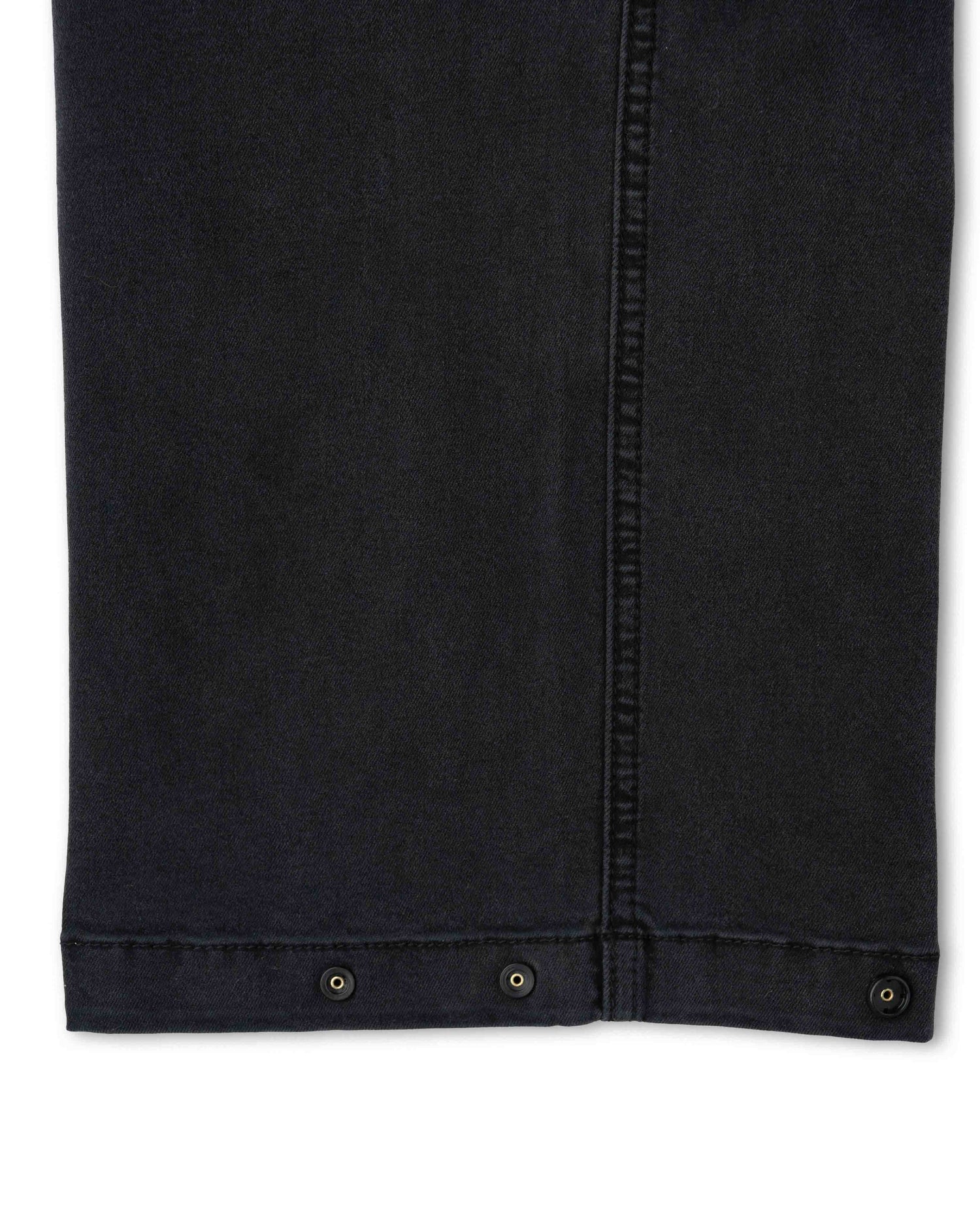 Close-up of a black denim jacket with button details on a white background