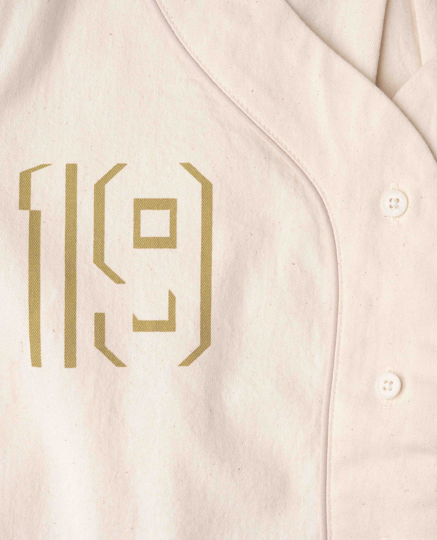 Close up of gold 19 on white shirt