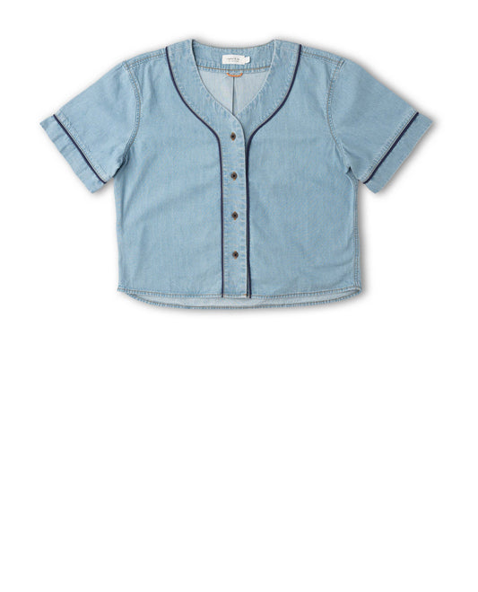 A light blue denim short-sleeve button-up shirt with dark contrast piping along the V-neck, cuffs, and front placket, displayed flat against a white background.