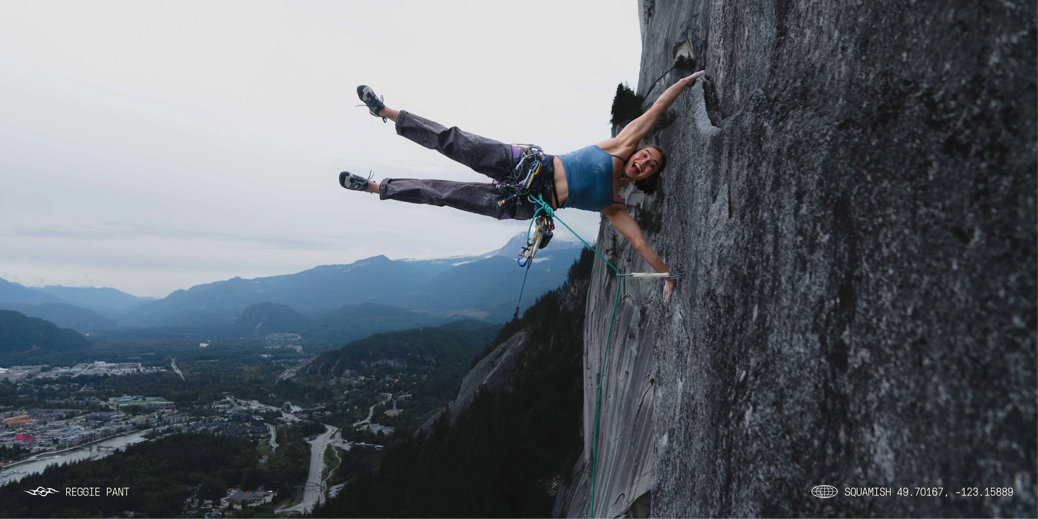 A women rock climbing wearing brown pants. 